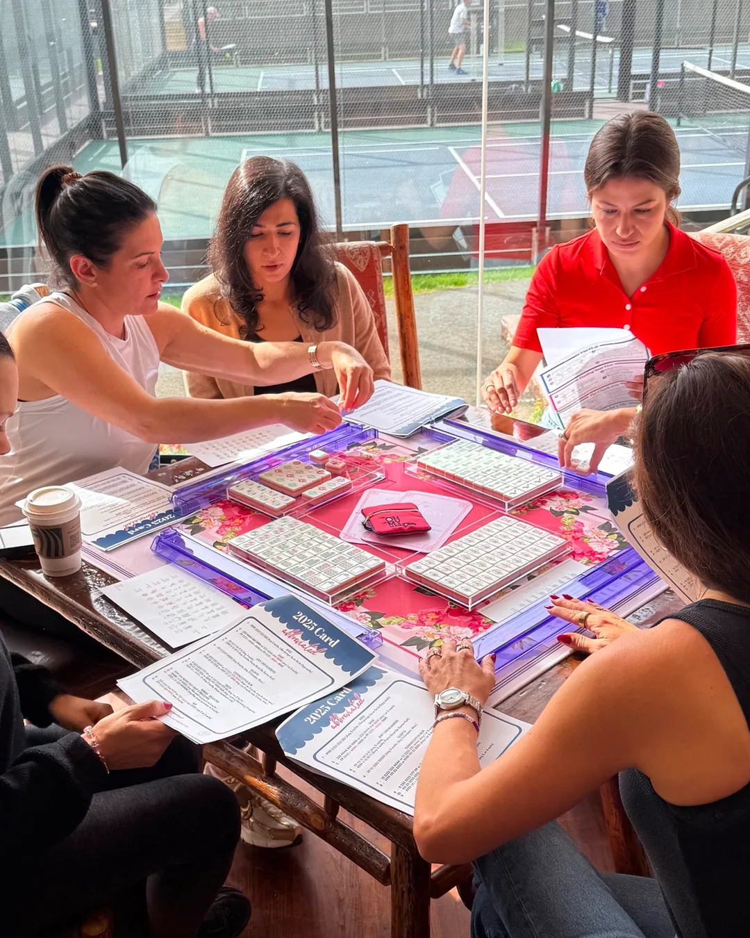 Members of The Tile Society playing Mahjong together at the table in Wyckoff, NJ